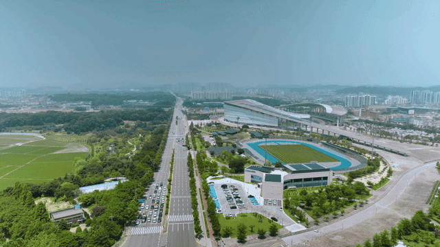 Road scene next to stadium harmoniously blended with greenery
