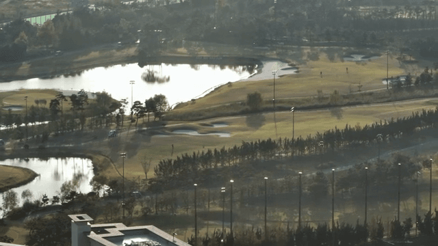 A golf course with ponds and trees