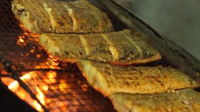 Spanish mackerel grilling over an open flame