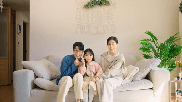 소파에 함께 앉아 포즈를 취하는 가족