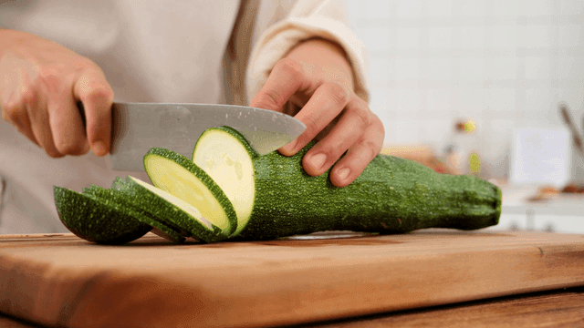 Cutting zucchini on wooden cutting board