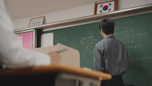 Teacher explaining math on a chalkboard
