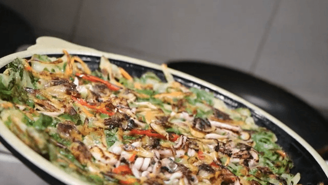 팬에서 요리한 해물 파전 그릇에 담기