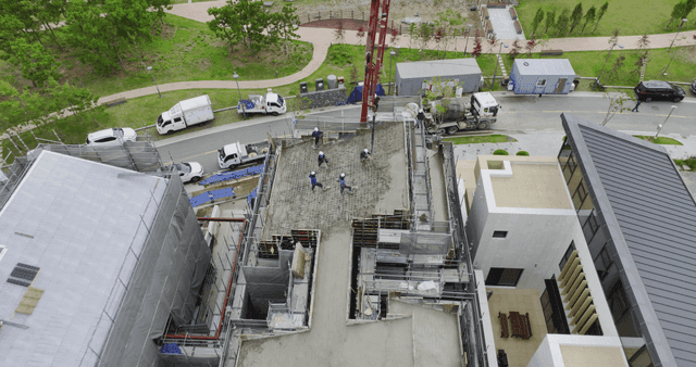 Construction workers pouring concrete on a building