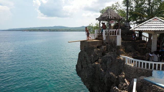 Group of friends cliff diving on a sunny day