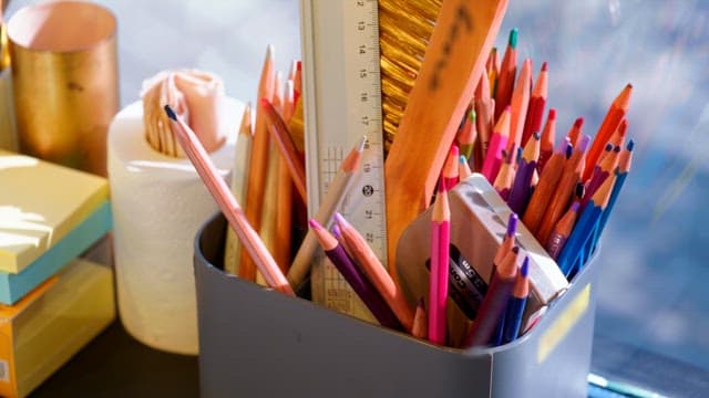 Colorful colored pencils in the pencil holder on the desk