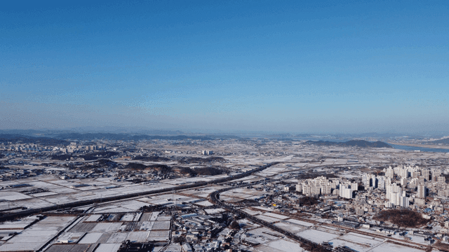 Aerial view of a snowy city and fields