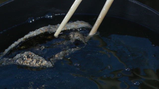 젓가락으로 뜨거운 기름에 김 부각을 튀기기