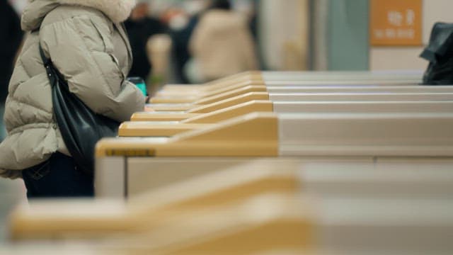 People passing through subway turnstiles