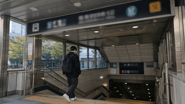 Back view of man entering subway station