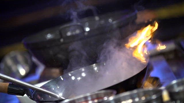 Flames rising from a pan during cooking