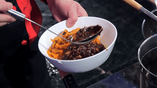 Putting Black Bean Sauce on top of Spicy Seafood Noodle Soup