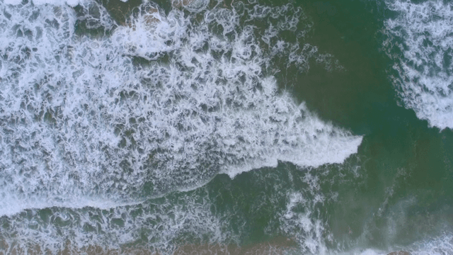 모래 해변에 부딪히는 파도