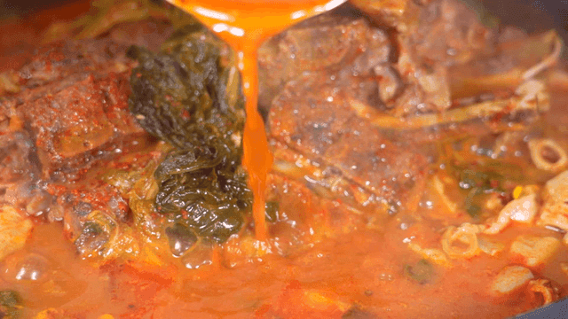 Pork backbone stew with boiling broth poured from pot