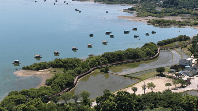 Scenic lake with floating cabins and greenery