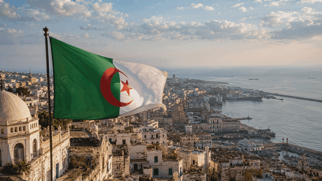 Algerian flags fluttering in wind and cityscape