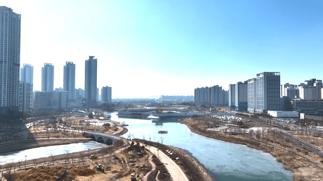 Modern city skyline with a river and park