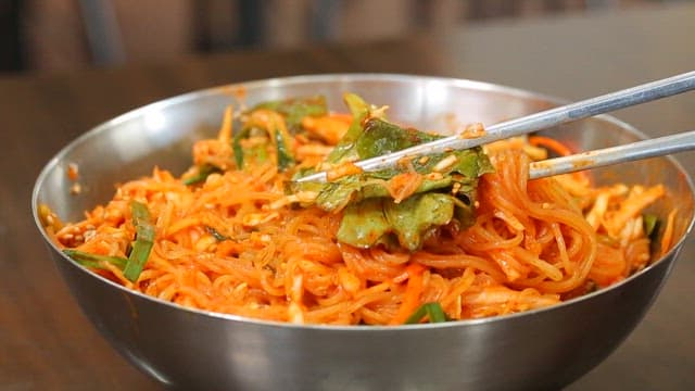 신선한 채소가 들어간 먹음직스러운 비빔쫄면 한 젓가락