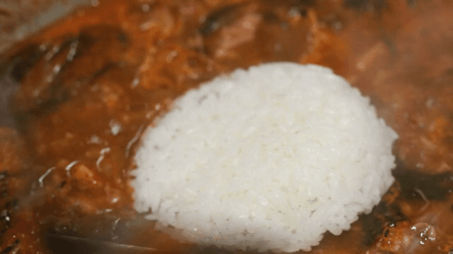 Rice being added to lamb hot pot
