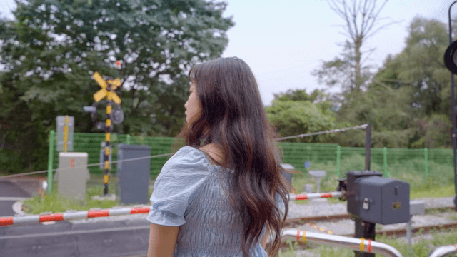 철도 건널목에서 기다리는 여성