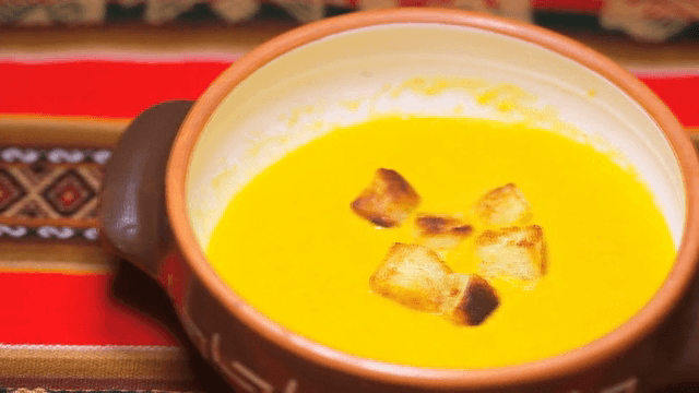 크루통이 올려진 노란 수프 한 그릇