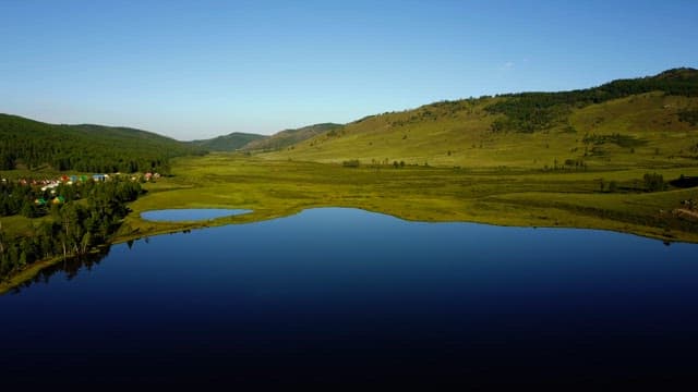 Tranquil lake surrounded by green hills