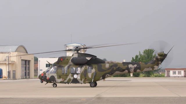 Person disembarking from a military helicopter on the runway