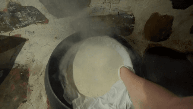 떡을 만들기 위해 솥에 쌀가루를 찌는 장면