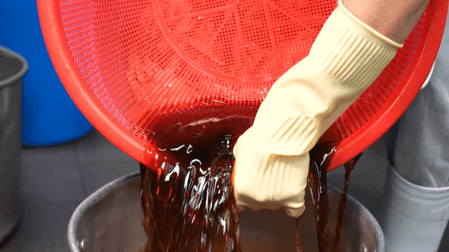 Scene of pouring soy sauce into pot through sieve