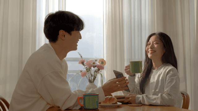 Couple smiling while looking at smartphone