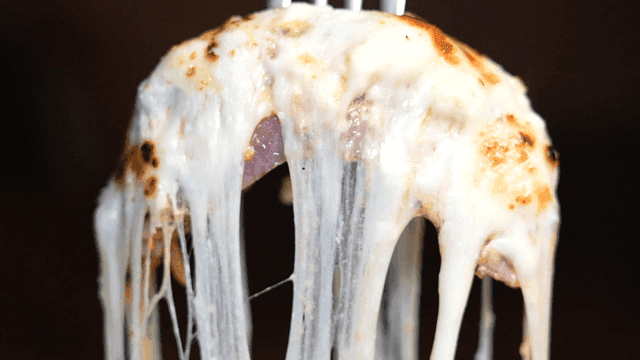 Melted cheese steak stretching on plate
