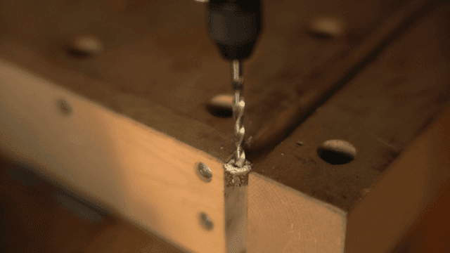 나무 판자에 드릴로 구멍 뚫기