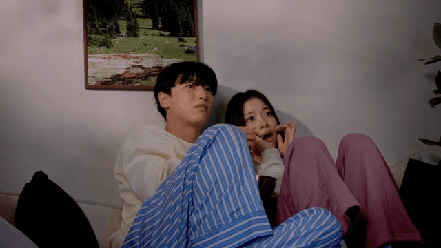 집 소파에서 무서운 영화를 보는 커플