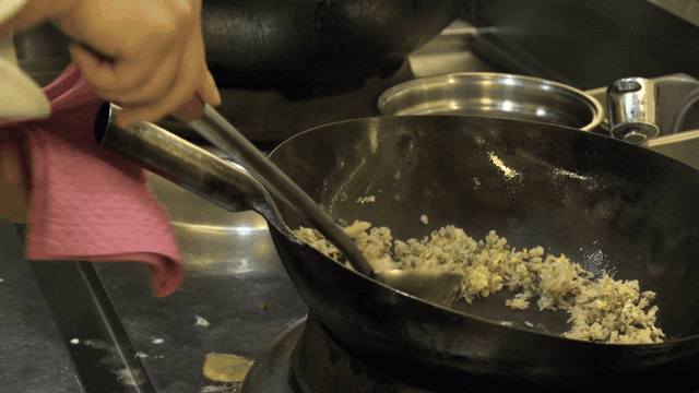 Chef cooking fried rice in hot wok