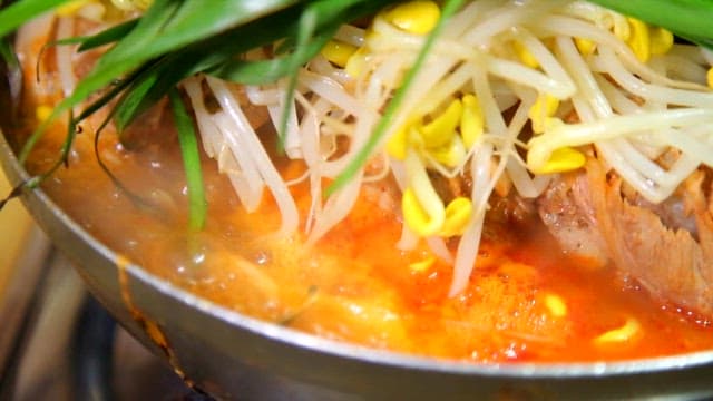 Pork backbone stew topped with chives and bean sprouts