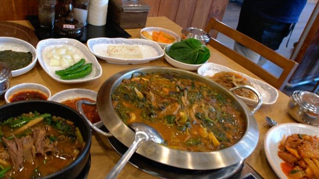 다양한 음식과 반찬이 푸짐하게 펼쳐진 식당의 테이블