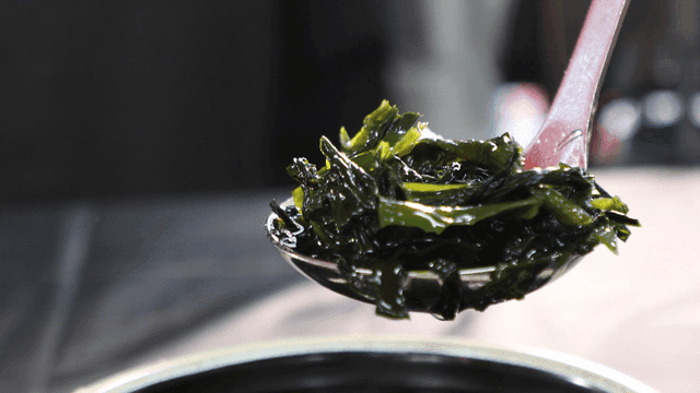 Ladle used to scoop out cold seaweed soup from bowl