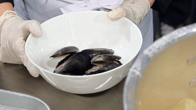 끓는 국물 옆 그릇에 담긴 홍합