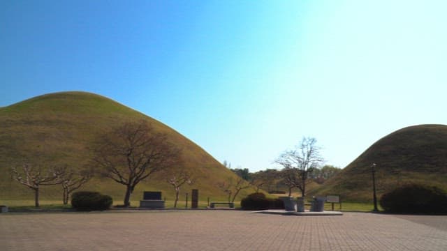 Early morning at a historic site with a view of the green tombs