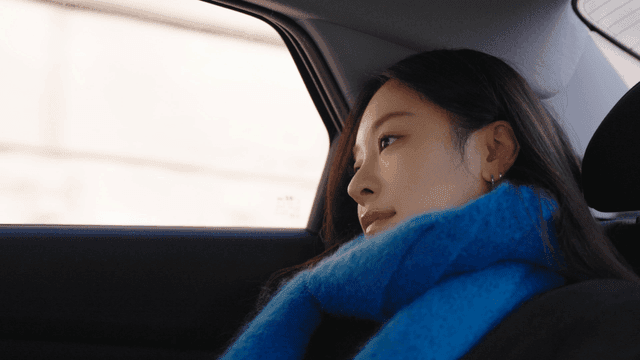 Side view of a woman leaning against the back seat of a taxi