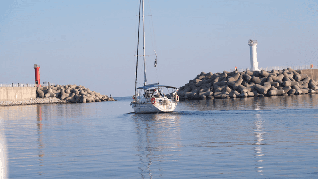 Yachts sailing between breakwaters