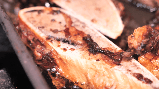 Beef bones sizzle on hot grill