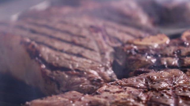 뜨거운 철판에서 맛있게 구워지는 스테이크