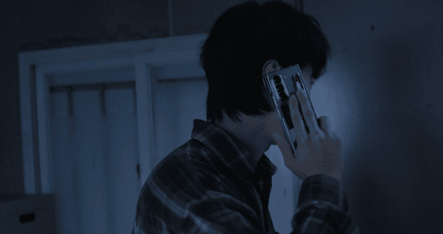 Angry man talking on cell phone in dark room