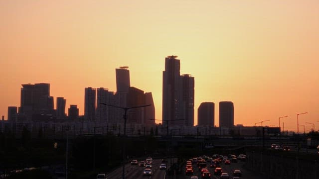 Sunset over Busy Urban Roadway Silhouetting Skyscrapers