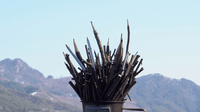 산 배경의 나뭇가지 연필 조각품