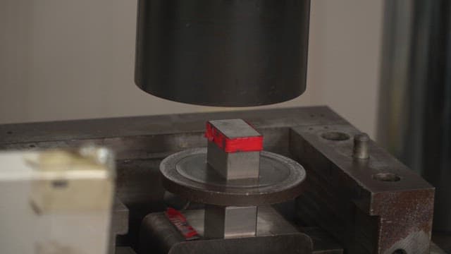 Metal being pressed in a hydraulic machine