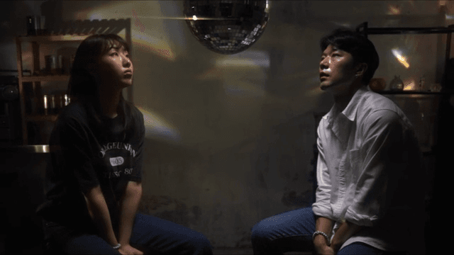 Two people sitting under a disco ball