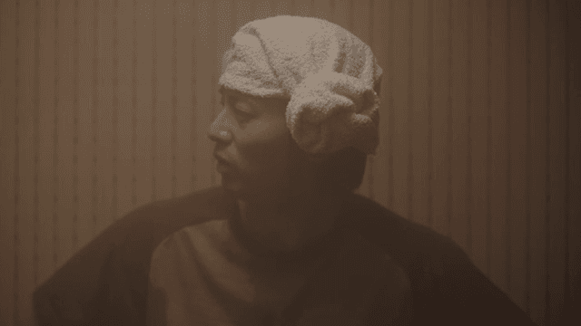 사우나에서 수건을 머리에 두른 사람