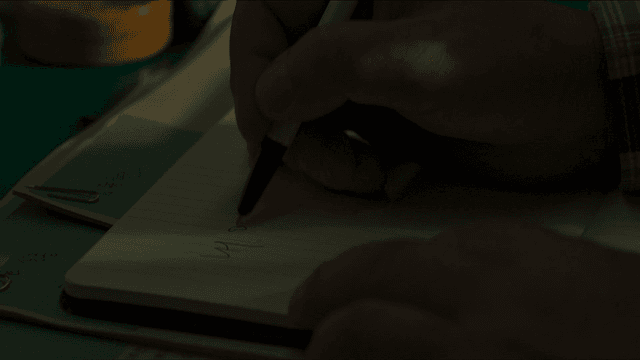 어두운 방에서 내 아들이라고 메모를 하는 사람의 손